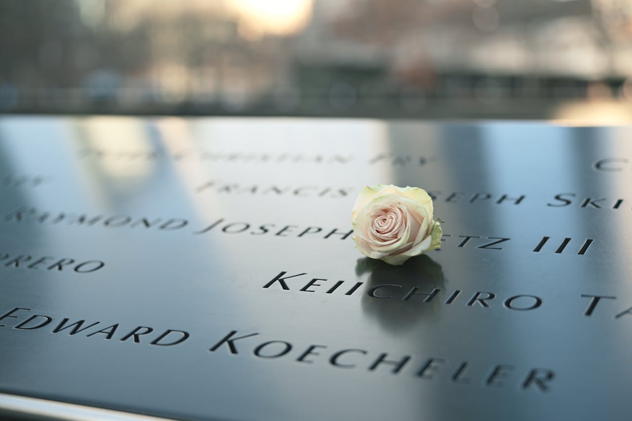 Crafting Captivating Headlines: Your awesome post title goes here A white rose placed on the 9/11 Memorial with engraved names, symbolizing tribute.
